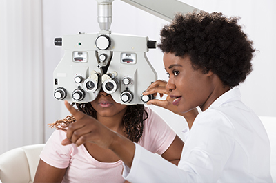 An optometrist conducting an eye exam on a patient using a slit lamp.