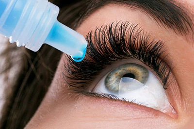 The image shows a close-up of a person s eye with an eyeliner applicator resting on their eyelashes, demonstrating how to apply eyeliner.